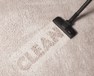 A vacuum cleaner cleaning the word "clean" on a carpet, ensuring a spotless and tidy environment.
