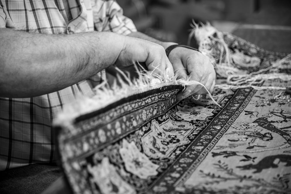 Close-up of fringe repair on a handwoven Persian rug by a restoration expert in Vancouver