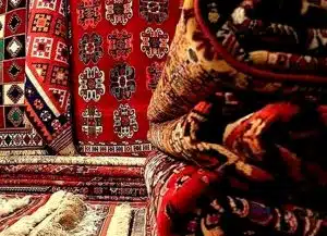 Rolled Persian and Oriental rugs with rich red patterns ready for expert cleaning and restoration in North Vancouver